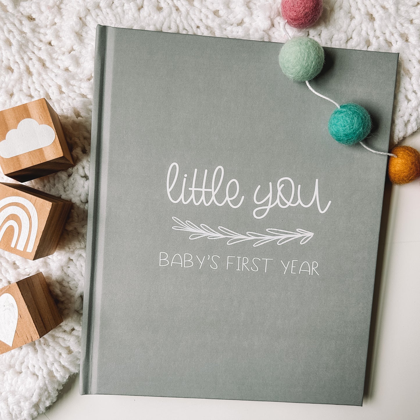 Keepsake baby book with a grey cover titled Little You Baby's First Year in white text.