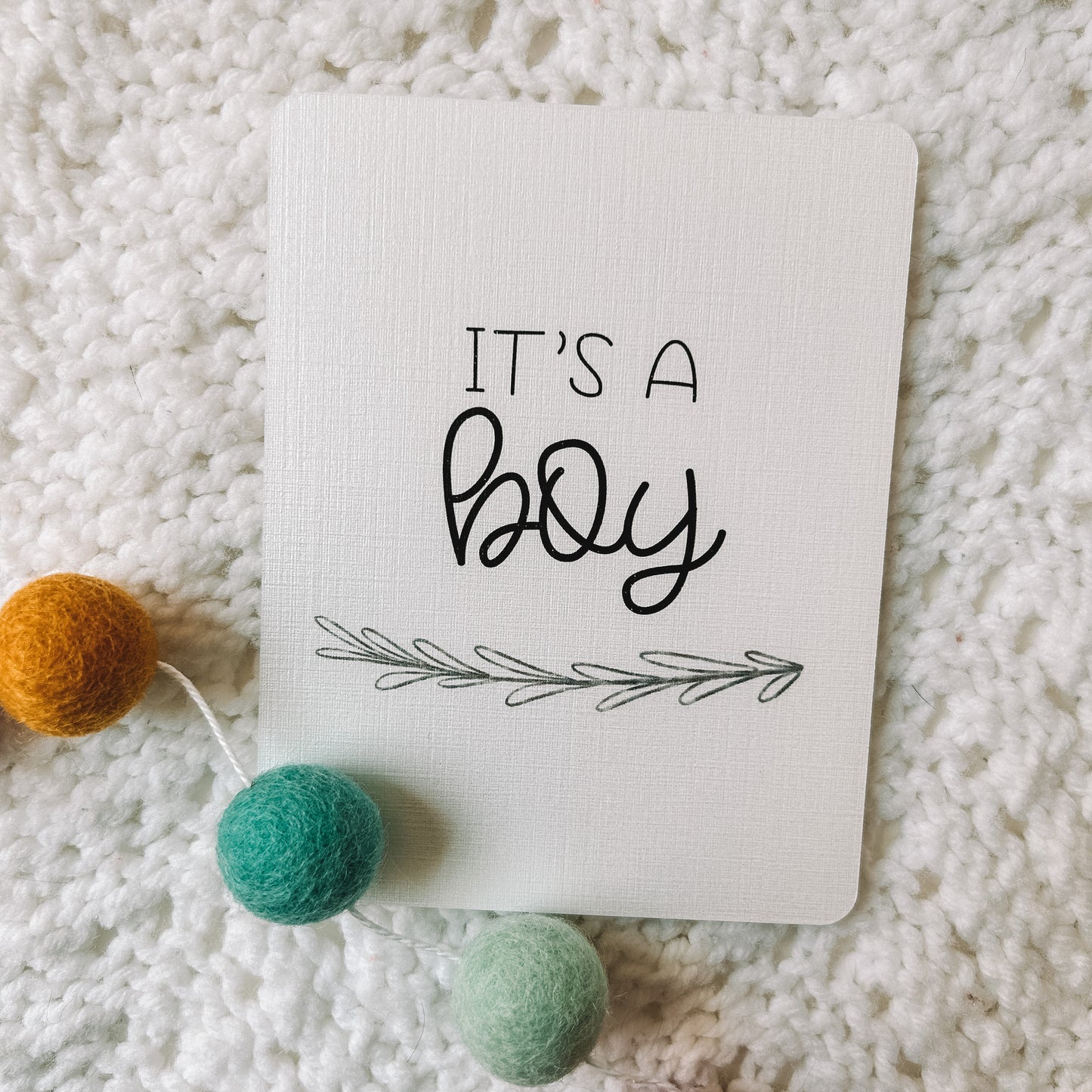 Milestone card with the text it's a boy and leafed branch beneath it.