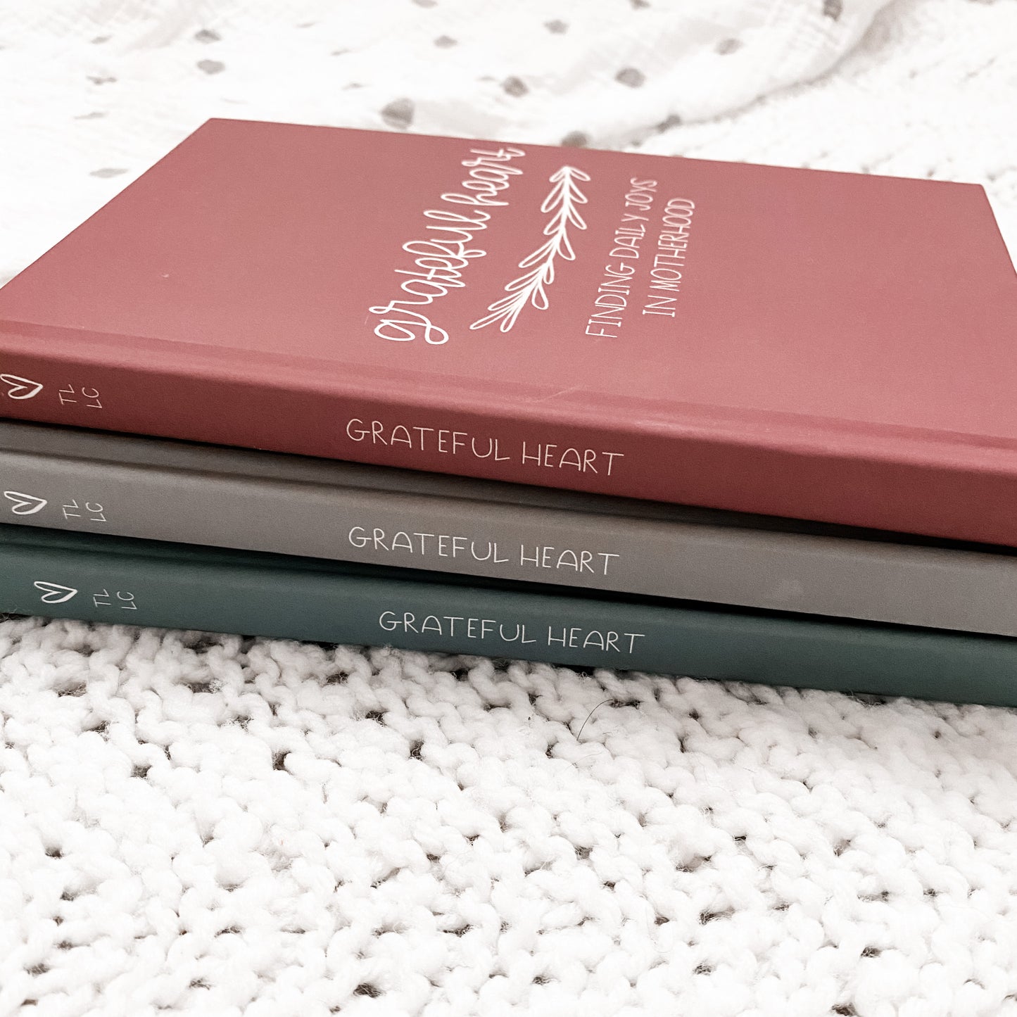 Side view of hard cover journals has a heart, TLLC, and Grateful Heart printed on the spine