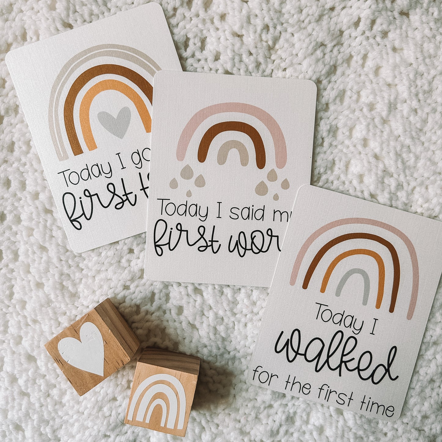 Today I got my first tooth, today I said my first word, and today I walked for the first time milestone cards with a rainbow above the text