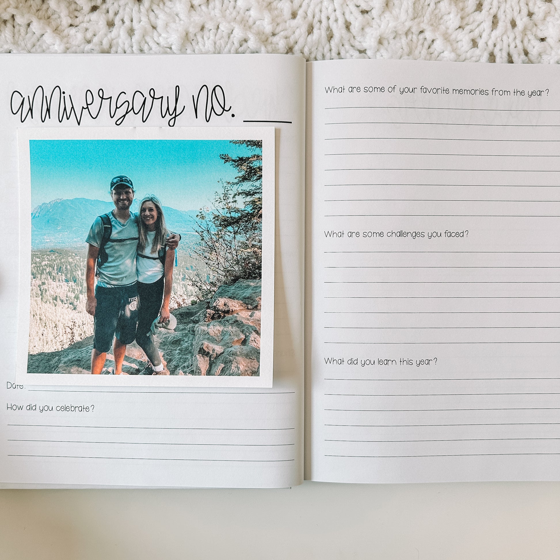 Two page spread in prompted anniversary journal. Left page is titled anniversary no. with a line next to it. There is photo with prompts beneath it. Right page has prompts with lines beneath the prompts.