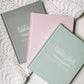 The baby book is available in three colors which are grey, blush pink, and sage green. All feature the title of the book, Little You Baby's First Year, printed in white ink.