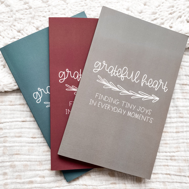 Blue, maroon, and grey gratitude journals titled Grateful Heart Finding Tiny Joys in Everyday Moments