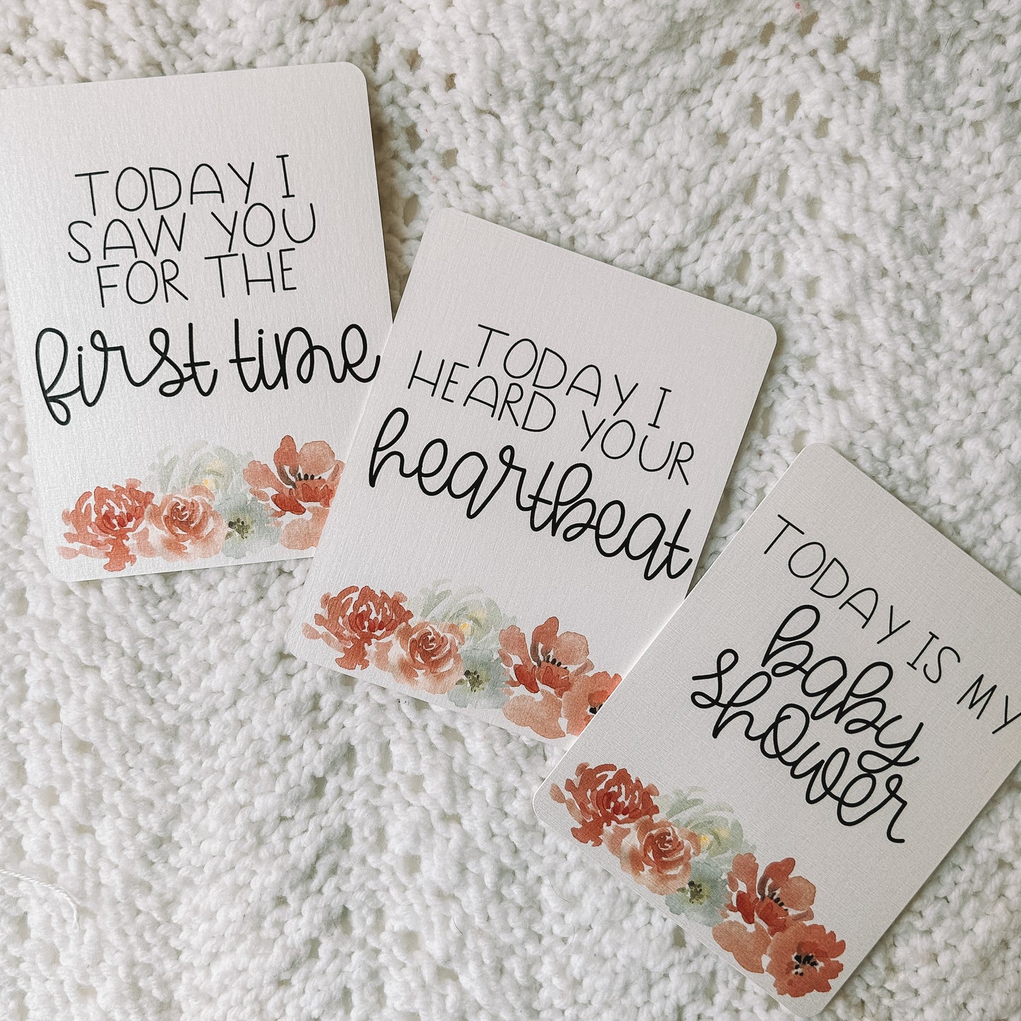 Three milestone cards with black text and flowers at the bottom of the card. They read Today I saw you for the first time, today I heard your heartbeat, and today is my baby shower.