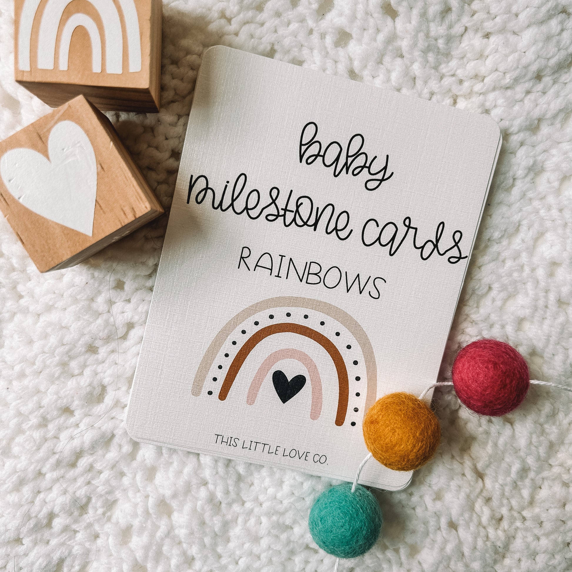 cover card that reads baby milestone cards rainbows with an image of a rainbow below. This Little Love Co is in small text at the bottom of the card