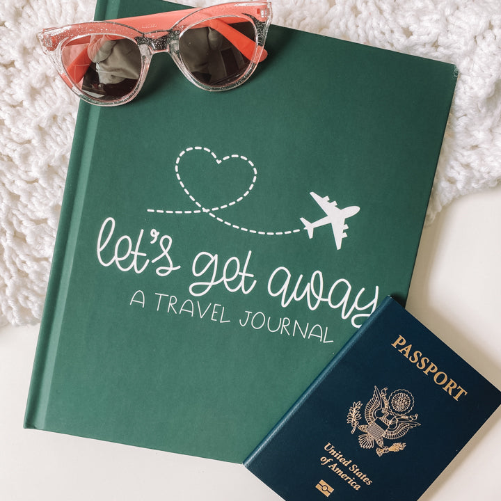 Keepsake travel journal with a soft, matte green hardcover. White text reads Lets Get Away A Travel Journal with a graphic of a white airplane leaving a heart trail behind it.