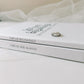 Engagement journal stacked on top of anniversary journal with set of wedding rings on top